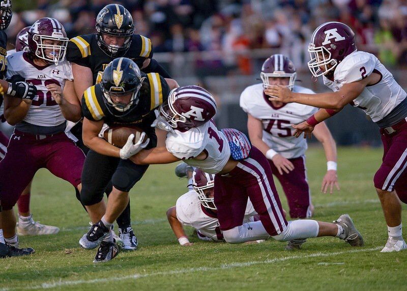 Ada’s George Maddox (19) grabs a Tecumseh runner and gets help from Caden Balthrop (52) and Nate Richardson (2) during a District 4A-2 contest Friday night in Tecumseh. Maddox recorded a team-high 10 tackles in the Ada victory.