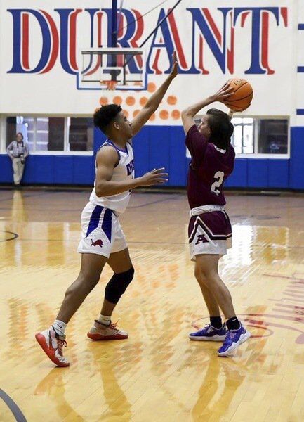 Carizma Nelson | For The Ada News -- Ada junior Cooper Patterson keeps the ball away from the opposition during a Monday afternoon contest with host Durant. The Cougars won 62-52.